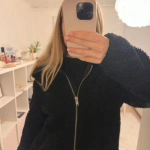 Svart teddyjacka med dragkedja - Mysig svart teddyjacka med fluffig yta och hel dragkedja framtill. Jackan har långärmade ärmar och en loose passform som ger en chill vibe.❤️