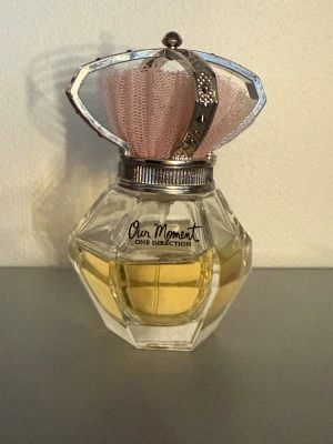 One Direction Our Moment parfym - Snygg parfym från One Direction med unik flaska och rosa detaljer. Perfekt för dig som vill ha en ikonisk doft i samlingen. Populär bland fans och trendmedvetna unga.
