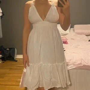 Vit klänning med snörning - Säljer en vit klänning med omlott och snörning i ryggen. Den köptes i Dubai på en marknad. Står ej storlek men jag gissar S/M. Den är använd men fortfarande i bra skick (snörret på ryggen har fått lite färg från användning men det syns inte mycket)❤️skicka gärna om ni har frågor 