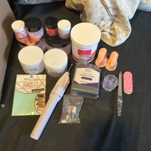 Stort kit med akrylpulver och nagelverktyg - Säljer akryl nagel grejer med flera burkar akrylpulver i rosa, vitt och korall (vissa öppnade). Akryl vätska som är oöppnad, elektrisk nagelfil med tillbehör, filar, borstar, träningsfingrar och nagelstickers. Finns även massa tippar 