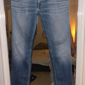 Blå Calvin Klein Jeans straight fit - Snygga ljusblå jeans från Calvin Klein Jeans med klassisk femficksdesign och broderad logga på linningen. Jeansen har raka ben och subtila slitningar. Passar dig som gillar tidlös stil och vill ha ett par jeans med bra passform.