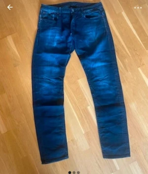 Mörkblå jeans från G-Star RAW L38 W38 - Snygga mörkblå jeans från G-Star RAW med klassisk femficksdesign och läderpatch bak i midjan. Jeansen har en slim passform och raka ben. Perfekt för dig som gillar streetstyle.