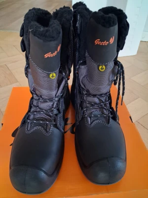 Svarta vinterstövlar Gesto Tor strl 40 - Svarta vinterstövlar från Gesto, modell Tor, med snörning och fluffigt svart foder. Stövlarna har robust platt sula, förstärkta detaljer och reflekterande inslag. Utsidan är i slitstark syntet och skinn, perfekt för kalla dagar. Snyggt orange logotyptryck på sidan.... ny pris 1700 kr