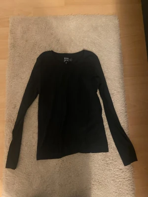 Svart långärmad tröja Basic You - En svart långärmad tröja från Basic You i storlek 158/164. Tillverkad av mjuk ekologisk bomull, perfekt för dig som gillar enkla och stilrena plagg. Rund halsringning och klassisk passform som funkar till många olika looks.