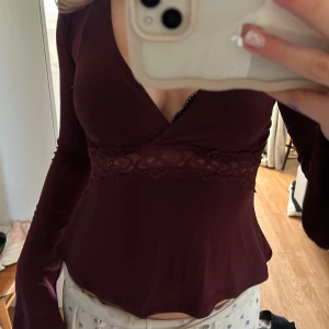 Vinröd v-ringad topp med spets från Gina Tricot❤️ - Säljer en vinröd topp från Gina Tricot i storlek XS. Toppen har lång ärm, v-ringning och en snygg spetsdetalj under bysten. Toppen är endast använd 2 gånger och är perfekt nu till vintern!