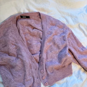 Ljuslila kofta från Bik Bok - Superfin ljuslila kofta från Bik Bok i stickad kvalitet med snyggt hålmönster!