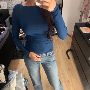 Långärmad topp  - Säljer en marinblå långärmad topp från Zara i storlek S. Toppen har en rund halsringning och är figurnära med stretchigt material som sitter snyggt mot kroppen. Som ny 
