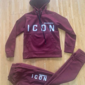 Vinröd hoodie DSQUARED2 ICON Ibrahimovic - Säljer en vinröd hoodie från DSQUARED2 x Ibrahimovic med stor vit 'ICON'-text och tryck både fram och bak. Hoodien har huva med snörning, magficka och långa ärmar. Materialet är mjukt och skönt, perfekt för en avslappnad stil.