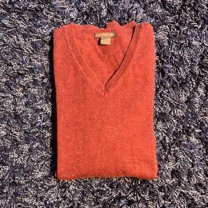 Vinröd v-ringad tröja från Selection - Vinröd v-ringad tröja från Selection, tillverkad i en mjuk mix av bomull, ull och kashmir. Klassisk modell med ribbade muddar vid halsringning, ärmslut och nederkant. Perfekt för lager-på-lager under kyliga dagar. Tröjan är lite nopprig, hör av er vid minsta fundering🙌