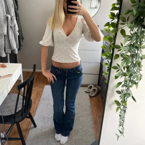 Mörkblå bootcut jeans låg midja - Snygga mörkblå jeans med bootcut och låg midja. Jeansen har klassisk femficksdesign och sitter tajt upptill med lätt utsvängda ben. Perfekta för dig som gillar en avslappnad men trendig look.