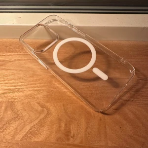 MagSafe-kompatibelt iPhone-skal - Transparent skal från Biltema med MagSafe-kompatibilitet, passar iPhone-modeller med stor kameramodul. Skalet är i mycket gott skick utan synligt slitage eller repor. Perfekt för att skydda din iPhone samtidigt som du kan använda MagSafe-tillbehör. Från Biltema.