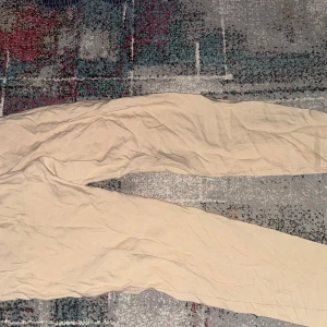 Dolce & Gabbana - Snygga beiga byxor från Dolce & Gabbana med resår i midjan för extra komfort. Byxorna har en rak passform och är tillverkade i ett mjukt tyg som känns skönt mot huden. Perfekta för en avslappnad och stilren look.