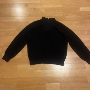 Svart ribbad tröja med half zip Kappahl - Svart ribbad tröja från Kappahl med halv dragkedja vid kragen. Tröjan har lång ärm och en klassisk, lite högre krage. Väldig bekväm men fortfarande väldigt snygg 