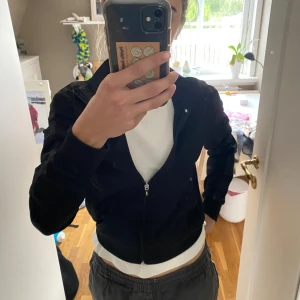 Svart track jacket från FILA XS - Svart track jacket från FILA i storlek XS. Jackan har dragkedja framtill, ribbade muddar och diskret FILA-logga på bröstet. Snygga detaljer med glansigt band längs ärmarna där det står FILA. Perfekt för en sportig och chill stil. Använd en gång💗