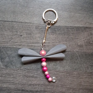 Reflex nyckelring trollslända  - Skapat av ljusrosa och mörkrosa reflexpärlor samt vingar gjorda av reflextyg. Trollslända är ca 5.5cm lång. Blir en fin accessoar till tex väskan 