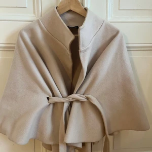 Missäy poncho - Säljer min super fina poncho från missäy ingen beige färg då den inte kommer I’ll använding längre!  (Har tagit bort den guldiga knappen, se bilder men kan stängas med en knapp som sitter på insidan) Annars i bra skick!