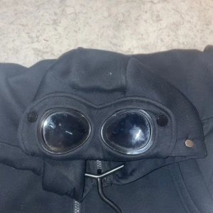 Cp. Company - Säljer denna riktigt fina tröja med luva som har glasögon på sig! Den är storlek S men liten i sig. Mycket fint skick på den. Kontakta vid frågor !