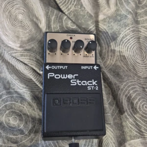 Boss Power Stack ST-2 - Boss Power Stack ST-2 gitarrpedal i fint skick. Ger autentiskt rörförstärkar-ljud med justerbara kontroller för Level, Bass, Treble och Sound. Batterifacket är rent och pedalen visar minimalt slitage. Perfekt för rock och metalgitarrister som vill ha kraftfullt sound.