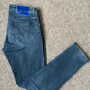 Jacob Cohën jeans - Snygga blå/gråa jeans från Jacob Cohen med klassisk femficksdesign och knappgylf. Jeansen är slimfit och storlek 34 (modell nick), tillverkade i Italien med högkvalitativt denimtyg 🇮🇹 Perfekta för en stilren look🥂priset är som alltid diskuterbart, skriv om du vill se fler bilder.
