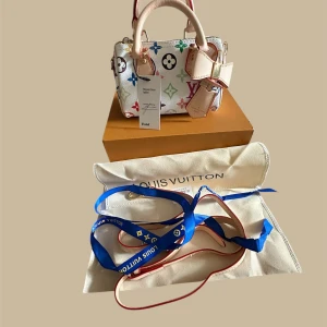 Louis Vuitton multicolor handväska - VERIFIED FRÅN VINTED Superfin handväska från Louis Vuitton i vitt skinn med ikoniskt multicolor-mönster och klassiska LV-loggor i olika färger.ej äkta  Väskan har ljusa handtag, avtagbar axelrem och snygga gulddetaljer. Kommer med dustbag och originalbox.