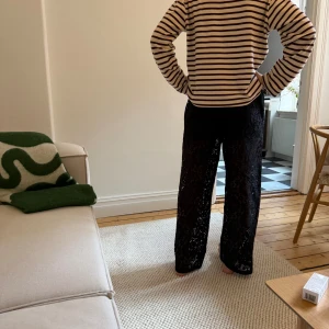 Svarta spetsbyxor - Säljer ett par svarta byxor i spets med rak och vid passform. Byxorna har elastisk midja och är använda en gång. Säljer då de inte används. Tjejen på bilden är 1,73m lång. 