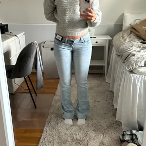 Ljusblå bootcut jeans med låg midja - Säljer ett par ljusblå jeans med bootcut-modell och låg midja. Jeansen har klassiska fem fickor, snygga sömmar på bakfickorna och är tillverkade i ett mjukt denimtyg. Perfekta för dig som gillar en avslappnad men trendig look. Är lite för små för mig!
