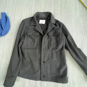 Bläck overshirt - Bläck overshirt som inte har några tecken på användning i storlek S förutom blå pricken på bild 3. Vid frågor är det bara att höra av sig!