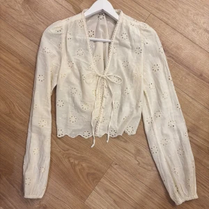 Blommig gul blus Nelly - Supersöt blus med broderade blommor och v-ringning. Från Nelly & strl 34🩷