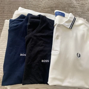 T-shirtpaket från Under Armour, BOSS & Fred Perry - Säljer ett paket med sex t-shirts: två Under Armour i grått och rött obs  den röda u storlek L …2  BOSS i marinblått och svart med broderad logga, samt en vit Fred Perry piké med mörkblå detaljer. Alla i klassisk passform och mjuk bomull. Perfekt för dig som gillar stilrena märken.
