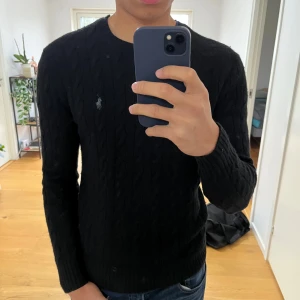 Kabelstickad ull-kashmir tröja Polo Ralph Lauren - Snygg svart kabelstickad raffe tröja. Ull och kashmir blend. Jag är 184 och passformen är slim. Nypris ligger på 2695kr. Tröjan är lite nopprig på vissa ställen men inga större defekter. Hör gärna av er vid frågor! 🙌🙌