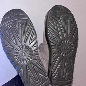 UGG Classic Mini Platform boots grå - UGG Classic Mini Platform boots i grå mocka med rund tå och plattformsula. Fodrade med mjukt foder för extra värme och komfort. Klassisk UGG-logga bak på hälen och dragflik för enkel påtagning. Perfekta för kalla dagar.                              