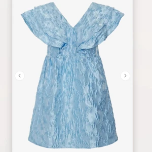 Ljusblå miniklänning med volang - Supersöt ljusblå miniklänning med strukturmönster och breda volangärmar. Från YAS, aldrig använd. Nypris 1000, pris kan diskuteras vid snabb affär.