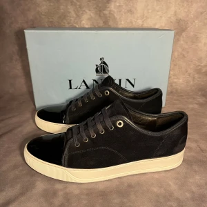 Svarta sneakers från Lanvin i mocka - Snygga Navy/mörkblå sneakers från Lanvin i storlek uk 8 sitter 43. Skorna är i bra skick,  defekter någon skrapa endast. 