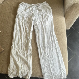 Vita linnebyxor med resårmidja - Luftiga och sköna vita linnebyxor med resår i midjan. Byxorna har raka ben och är tillverkade i tunt, svalt linnetyg som passar perfekt när det är varmt. Enkla att matcha och riktigt bekväma för chill dagar. Behöver strykas bara sen är dom som nya🥰