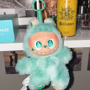 Biginto Energy The Monsters Plush Keychain - Söt och unik Biginto Energy The Monsters plyschfigur/nyckelring i mintgrönt. Perfekt skick, levereras med originalförpackning. Mjukt material, stora glittrande ögon och charmigt monsteransikte. Perfekt som present eller samlarobjekt.