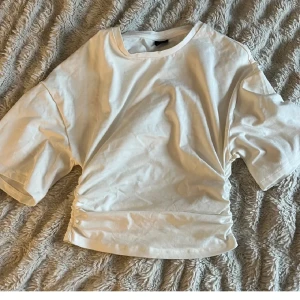 Snygg topp från Gina Tricot - Säljer en super snygg topp från Gina Tricot. Det är en kortärmad topp, tajtare vid midjan och lufftigare på den överdelen. . Perfekt för dig som gillar enkel stil med en twist. Passar till allt💕