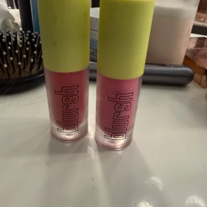 Blursh flytande rouge Posey & Rosey - Två flytande rouge från Blursh i nyanserna Posey och Rosey. Båda kommer i frostat rosa glas med limegröna lock och svart text. Perfekt för att ge kinderna en fräsch, rosig look. Smidig applikator och trendig design.