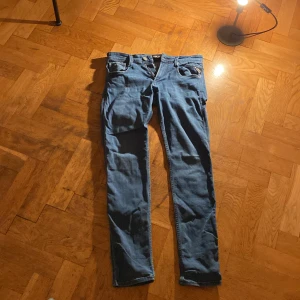 Blå Replay Anbass jeans slim fit - Snygga blå Replay Anbass jeans med klassisk femficksdesign och slim fit. Jeansen har normal midja, raka ben och är tillverkade i mjukt denimtyg med stretch för extra komfort. Perfekta för dig som gillar en stilren och modern look.