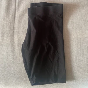 Svarta cykelshorts  - Svarta, tighta cykelshorts i mjuk bomull med elastisk midja. Perfekta för träning eller chill dagar. Klassisk och enkel design utan synliga detaljer eller mönster.
