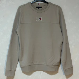 Sweatshirt från Tommy Hilfiger - Snygg grå/beige sweatshirt från Tommy Hilfiger med klassisk logga och tryck framtill. I bra skick! 