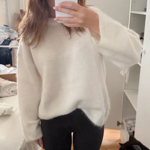 Vit fluffig stickad mohair tröja från H&M - Supermjuk och oversized vit stickad tröja från H&M. Tröjan har rund halsringning, långa ärmar och en riktigt fluffig känsla. Perfekt att mysa i under kyliga dagar och passar snyggt till både jeans och leggings.