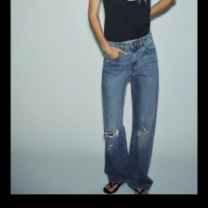 Blå wide jeans med slitningar - Intressekoll på dessa jeans från Zara. Dom är aldrig använda och har prislappen samt påsen dom kom i kvar. Dom är i storlek 36! 