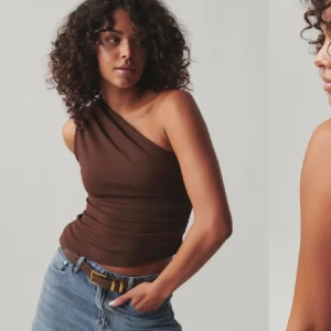 Oneshoulder topp  - Snygg brun oneshoulder topp från Ginatricot. Sitter tight och croppad på kroppen. Köpt sommaren 2024. Den är endast testad, tyvärr satt den lite för tight på mig. Nypris är 329kr!