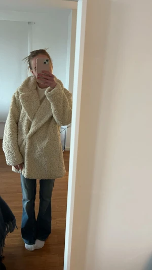 Beige teddyjacka med oversized passform - Mysig beige teddyjacka med stora slag och oversized passform. Jackan har lång ärm och är tillverkad i fluffigt teddy-material som ger en cool och avslappnad look. Perfekt för dig som vill ha en trendig och varm jacka till höst och vinter. Jackan är som ny och i storlek xs, den är i fuskpäls 