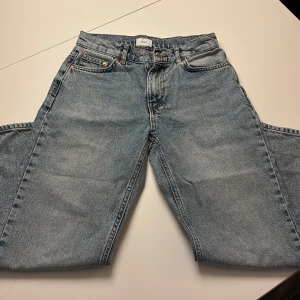 Blå vintage jeans från Grunt - Säljer ett par blå vintage jeans från Grunt med klassisk femficksdesign och raka ben. Jeansen har en ljus tvätt och extra fickor på benen för en cool utility-look. Materialet är robust denim och passformen är loose med midwaist.