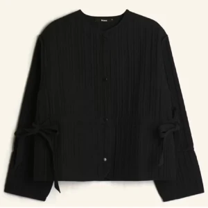 Svart quiltad jacka med knyt - Svart jacka från bikbok med quiltad struktur och rund hals. Jackan har knytband i midjan för en snatched look, tryckknappar framtill och långa ärmar. Nypris 699