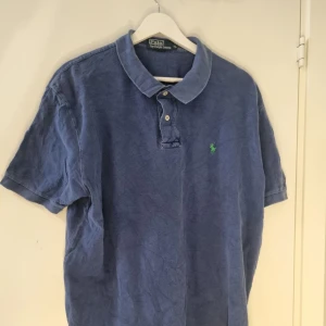 Ralph Lauren pike - Säljer en klassisk pikétröja från Ralph Lauren med korta ärmar. Perfekt för en stilren och avslappnad look.            