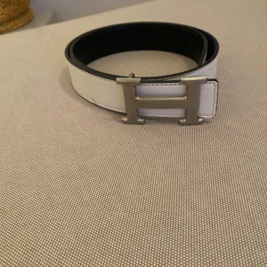 H bälte - Säljer ett H bälte i ny skick. Endast använd 1 gång. Riktigt stilrentbälte som passar till allt både. Bältet är i färg svart och vitt och man kan anpassa till sin outfit. Tveka inte på att höra av er