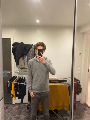 Grå hoodie i kashmir från Oscar Jacobson - Mjuk och stilren grå hoodie från Oscar Jacobson i kashmir. Klassisk modell med huva och långa ärmar, perfekt för dig som gillar en clean och enkel look. Tillverkad i Italien och passar dig som vill ha något både bekvämt och snyggt.