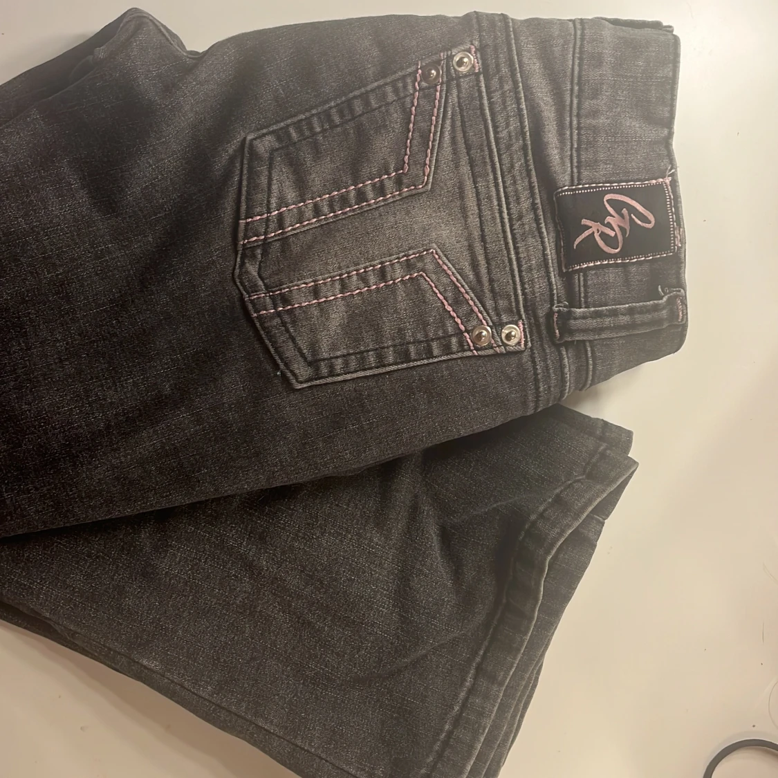 Grå bootcut jeans från G Rise med rosa detaljer.